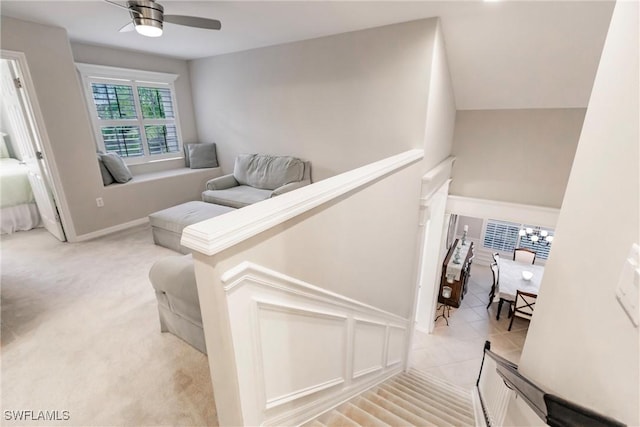 stairs featuring ceiling fan and carpet