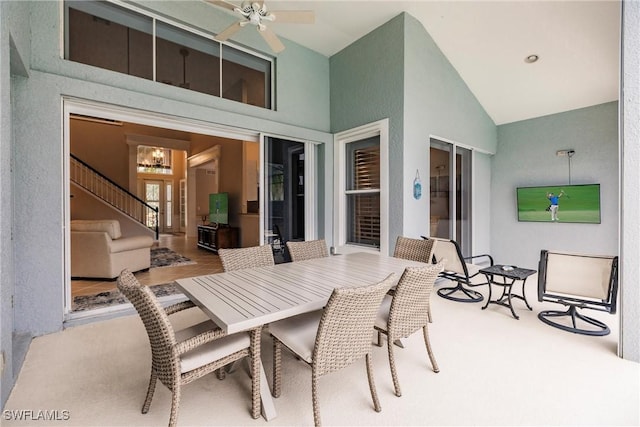 interior space with high vaulted ceiling and ceiling fan with notable chandelier