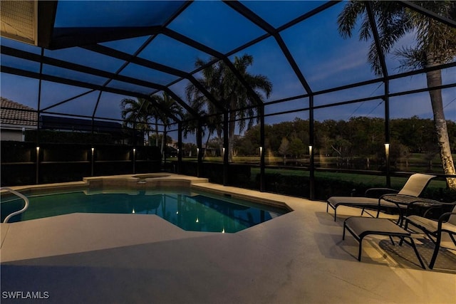 pool at dusk featuring a lanai and a patio area