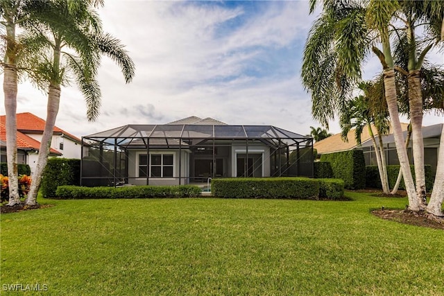 back of property with a lawn and glass enclosure