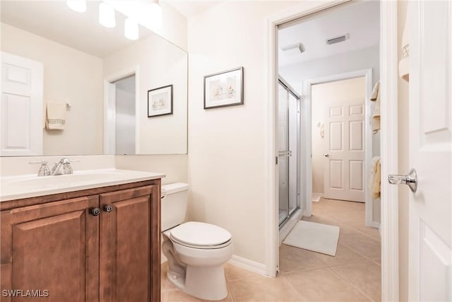 bathroom featuring tile patterned floors, vanity, toilet, and a shower with door