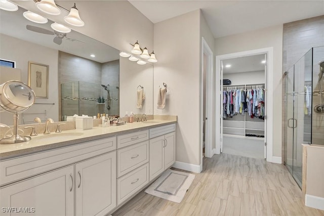 bathroom with vanity, an enclosed shower, and ceiling fan