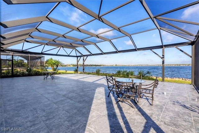 view of patio featuring a lanai and a water view