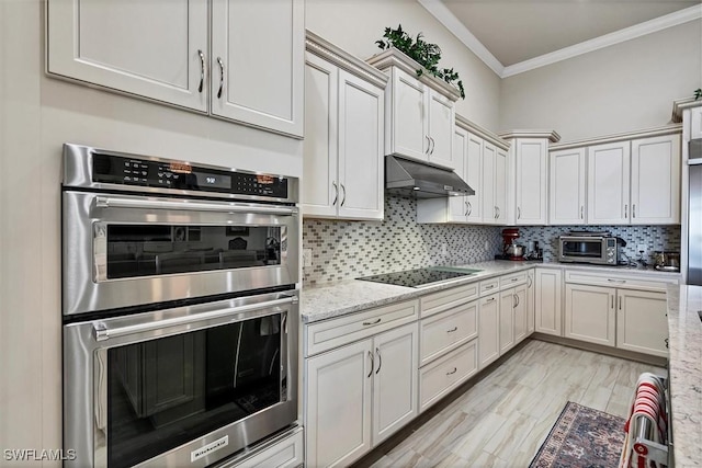 kitchen with light stone countertops, stainless steel double oven, crown molding, black electric cooktop, and decorative backsplash