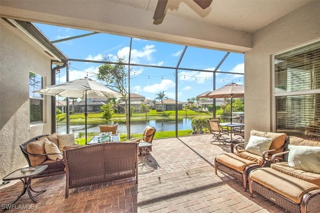 view of patio featuring outdoor lounge area, a lanai, and a water view