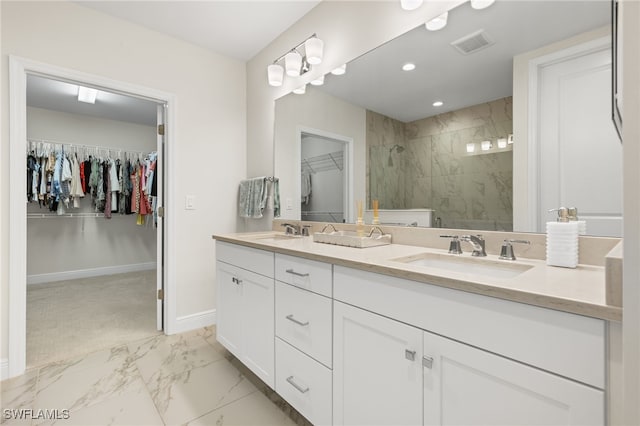 full bath featuring marble finish floor, a stall shower, a sink, and a walk in closet