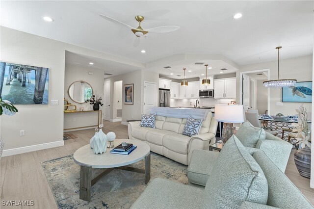 living room with ceiling fan and light wood-type flooring