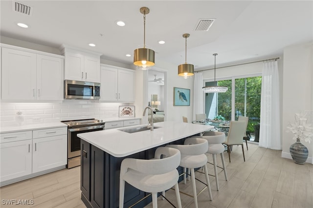 kitchen featuring appliances with stainless steel finishes, light countertops, and white cabinetry