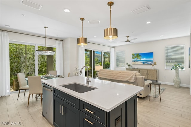 kitchen with dishwasher, light countertops, a sink, and pendant lighting