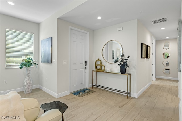 foyer featuring light wood-type flooring, visible vents, baseboards, and recessed lighting