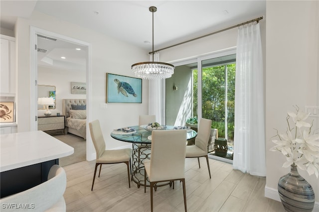 dining area featuring baseboards, recessed lighting, light wood-type flooring, and an inviting chandelier