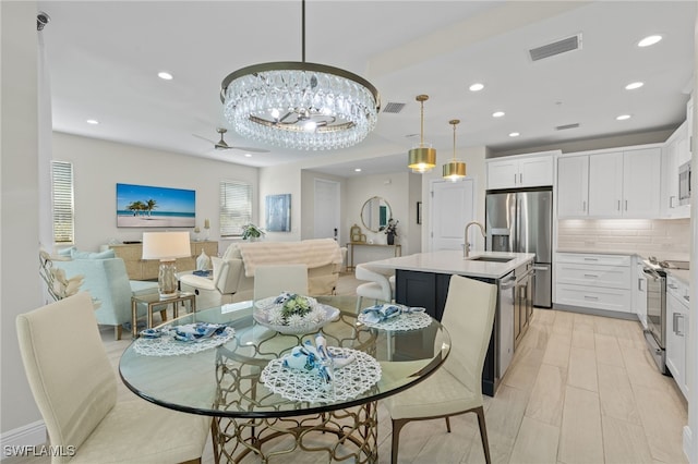 dining area with light wood-style floors, recessed lighting, visible vents, and ceiling fan with notable chandelier