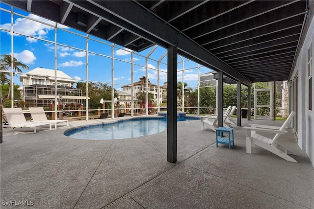 view of pool with glass enclosure and a patio area