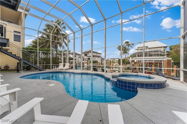 view of swimming pool with an in ground hot tub, a patio, and a lanai