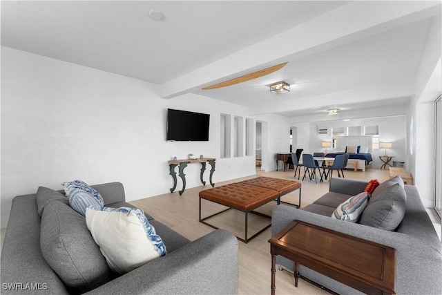 living room with beamed ceiling and light hardwood / wood-style flooring