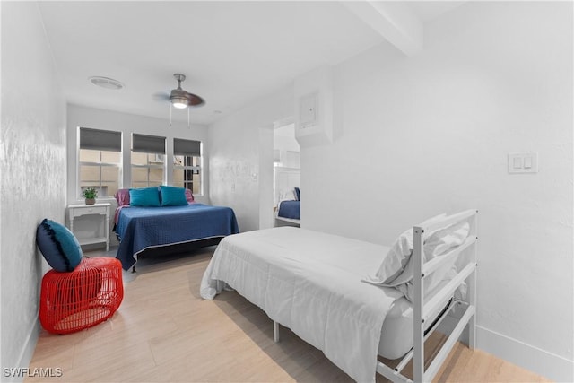 bedroom featuring beam ceiling, ceiling fan, and light hardwood / wood-style floors