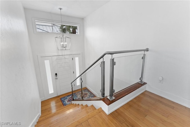 entryway with light hardwood / wood-style floors and a notable chandelier