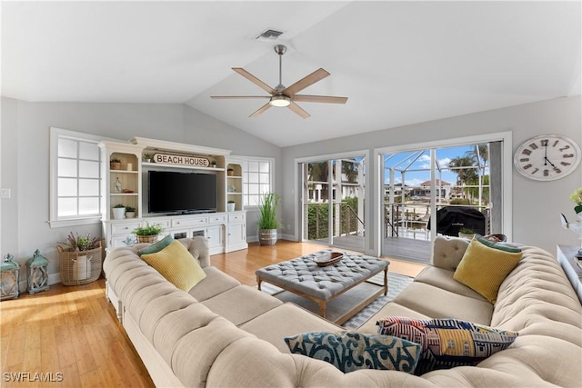 living room featuring ceiling fan, plenty of natural light, lofted ceiling, and light hardwood / wood-style flooring