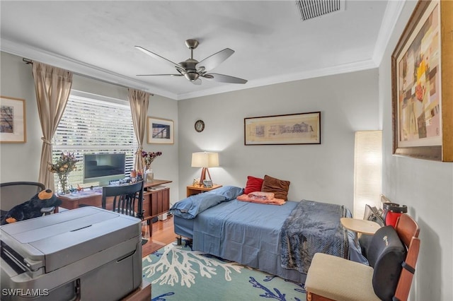 bedroom with ceiling fan, ornamental molding, and hardwood / wood-style floors