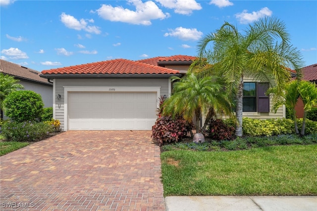 mediterranean / spanish-style home featuring a front yard and a garage