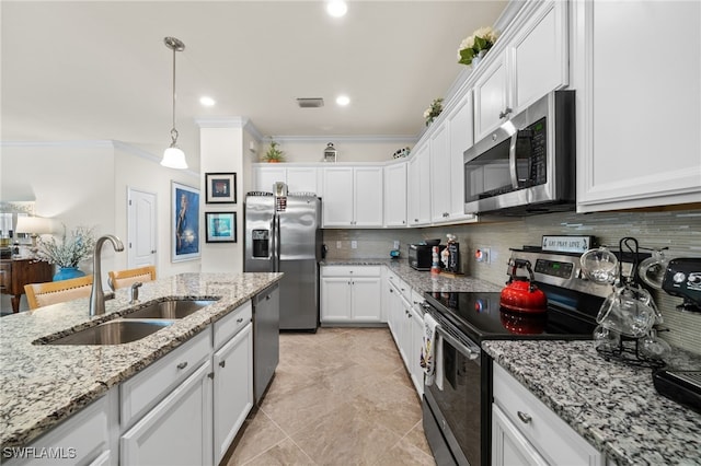 kitchen with light stone counters, stainless steel appliances, white cabinetry, and sink