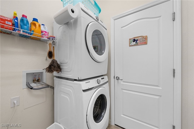 clothes washing area with stacked washer and clothes dryer