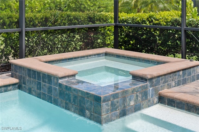 view of swimming pool with an in ground hot tub