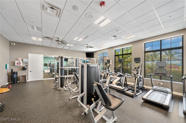 exercise room with a paneled ceiling and ceiling fan