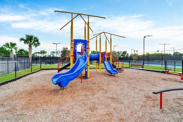 view of jungle gym featuring tennis court