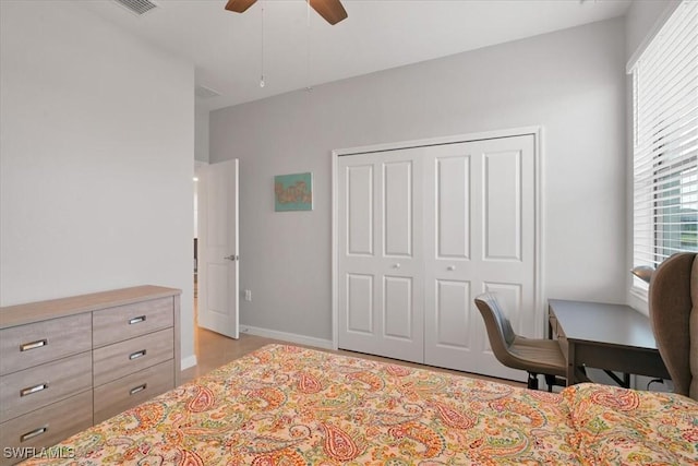 bedroom with ceiling fan, multiple windows, and a closet