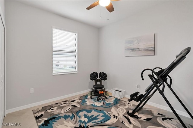 workout room featuring ceiling fan and light tile patterned floors