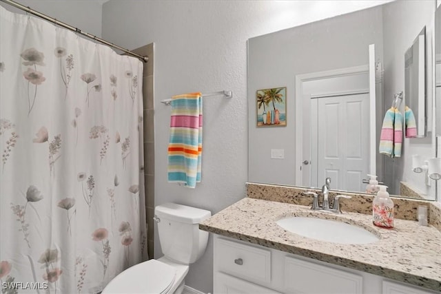 bathroom featuring vanity, toilet, and curtained shower