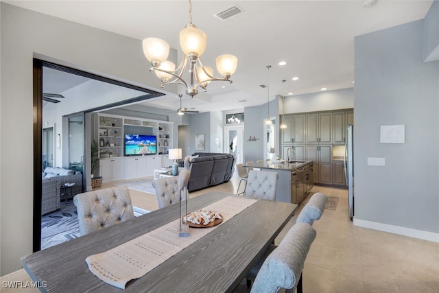 dining room with built in shelves, sink, and ceiling fan with notable chandelier