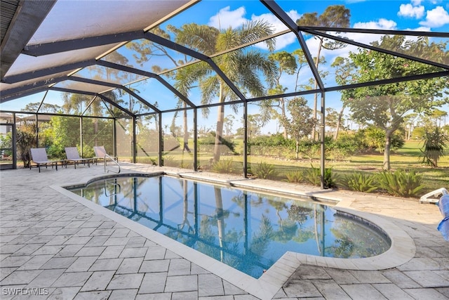 view of swimming pool with glass enclosure and a patio area