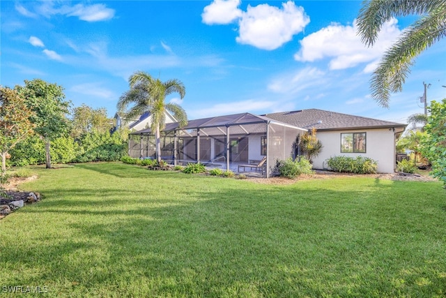 rear view of house with a lanai and a yard