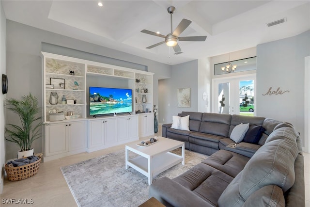 living room featuring french doors, coffered ceiling, built in shelves, ceiling fan with notable chandelier, and beam ceiling