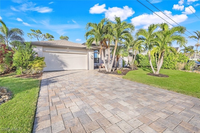 view of front of home with a front yard and a garage