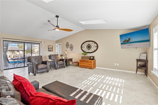 living room featuring tile patterned floors, ceiling fan, and lofted ceiling with skylight