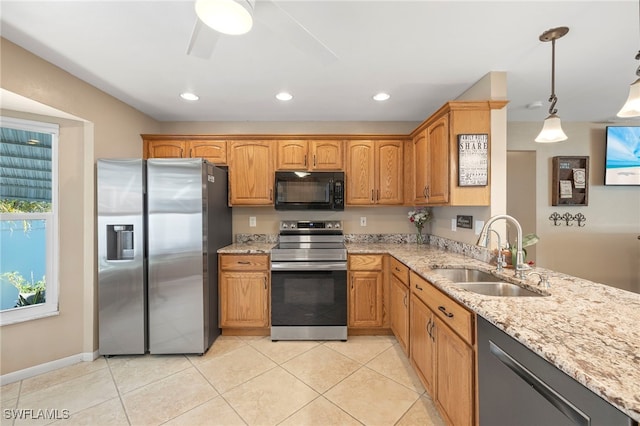 kitchen with hanging light fixtures, sink, ceiling fan, light stone countertops, and appliances with stainless steel finishes