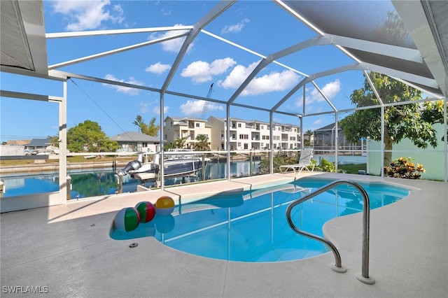 view of swimming pool with glass enclosure, a water view, a patio, and a boat dock