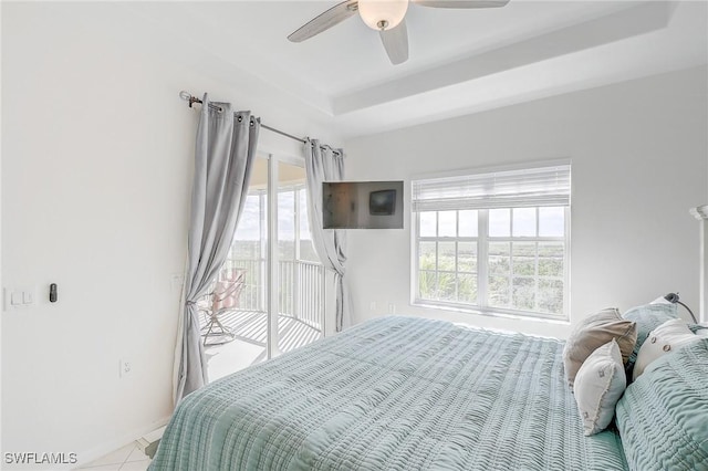 bedroom with access to outside, a raised ceiling, ceiling fan, and light tile patterned floors