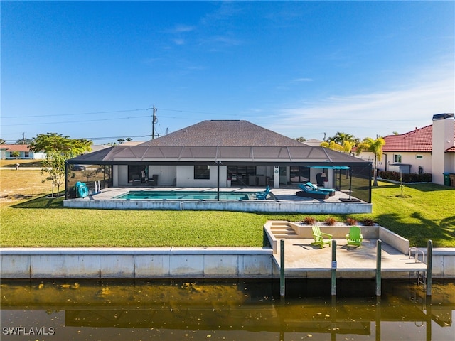 rear view of house with a water view, a yard, a lanai, and a fenced in pool