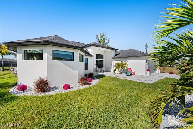 rear view of property featuring a yard and a patio area