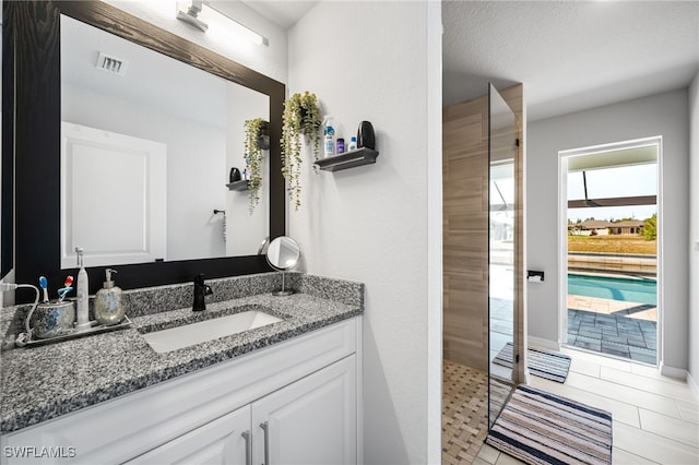 bathroom featuring vanity, a textured ceiling, and a shower