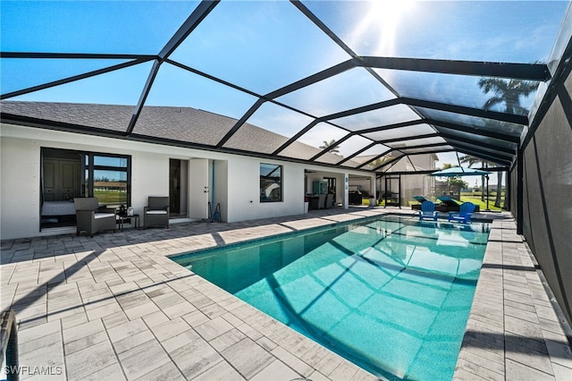 view of swimming pool featuring glass enclosure and a patio area