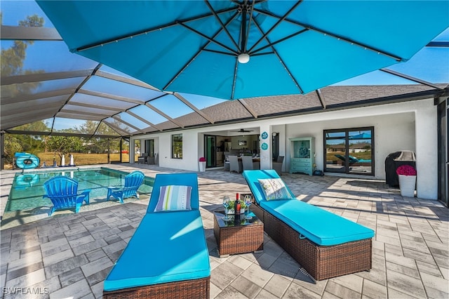 view of patio / terrace featuring ceiling fan, sink, and glass enclosure