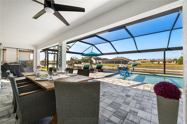 view of patio / terrace featuring ceiling fan and glass enclosure