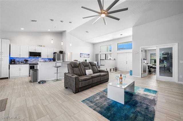 living room with high vaulted ceiling and ceiling fan