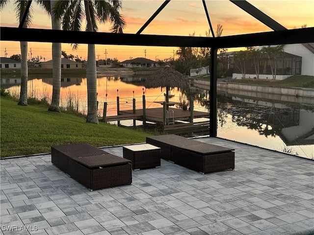 exterior space featuring a water view, a patio area, and a lawn