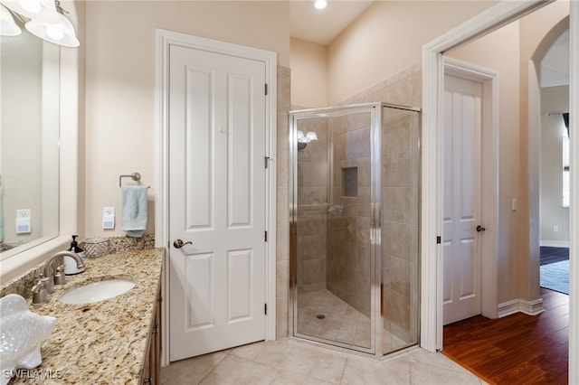 bathroom with walk in shower, vanity, and tile patterned flooring